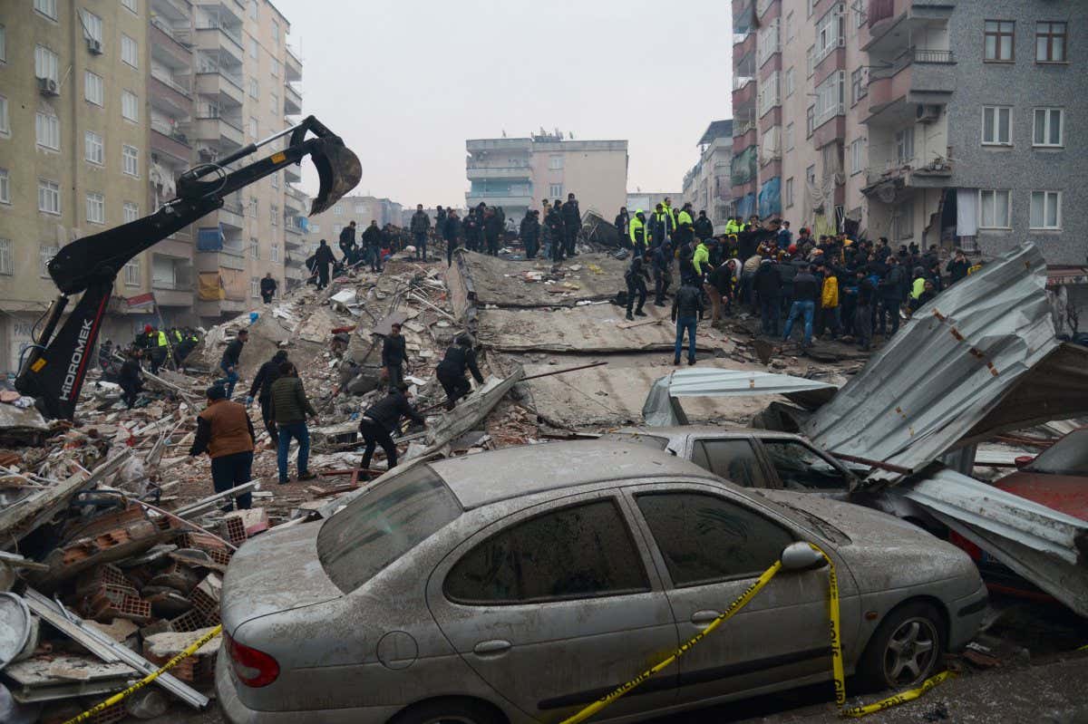 TOPSHOT - People search for survivors in Diyarbakir, on February 6, 2023, after a 7.8-magnitude earthquake struck the country's south-east. - At least 284 people died in Turkey and more than 2,300 people were injured in one of Turkey's biggest quakes in at least a century, as search and rescue work continue in several major cities. (Photo by ILYAS AKENGIN / AFP) (Photo by ILYAS AKENGIN/AFP via Getty Images)